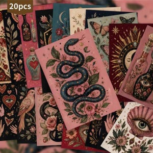 May include: A set of 20 decorative cards featuring various illustrations including a coiled snake, butterflies, birds, eyes, hands, and ornate bottles. The designs incorporate floral elements, celestial motifs, and a colour palette of pink, black, and gold.