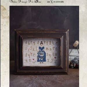 Op de afbeelding: Borduurpatroon met een vrouw in een blauwe jurk die een boeket bloemen vasthoudt. Het patroon bevat het alfabet en de tekst "When Flowers Blossom" en "Lana Lenskaya, 2022".