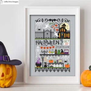 May include: A framed cross-stitch design with a Halloween theme. The design features a haunted house, ghosts, pumpkins, and the text "Halloween Spooktacular Oct 31st". A witch's hat and a carved pumpkin are in the foreground.