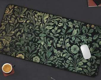 May include: A black mouse pad with a green and gold floral pattern. The pattern features intricate leaves and flowers.