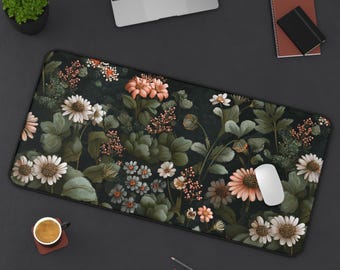 Puede incluir: Alfombrilla de ratón rectangular con fondo oscuro y diseño floral con flores blancas, melocotón y azules. La alfombrilla tiene un borde negro y un ratón de ordenador blanco.