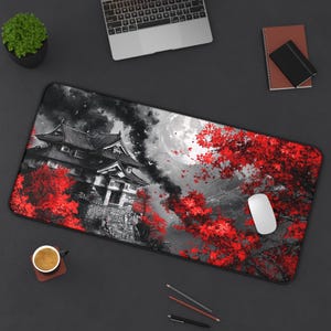 Puede incluir: Una alfombrilla de ratón en blanco y negro con un castillo japonés rojo y blanco y árboles de cerezo en flor. El castillo está en primer plano y los árboles de cerezo en flor están en el fondo. La luna es visible en el cielo.