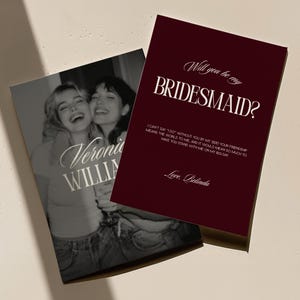Może przedstawiać: Prostokątna kartka z głębokim bordowym tłem z białym napisem Will you be my BRIDESMAID? wraz z osobistą wiadomością i podpisem Love, Belinda, nałożona na czarno-białe zdjęcie dwóch uśmiechniętych osób.