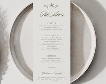 Puede incluir: Una tarjeta de menú rectangular vertical impresa en papel blanco roto con texto gris oscuro. El encabezado dice The Menu, seguido de secciones para Starter, Main Course y Dessert. La parte inferior incluye los nombres Sophia & Derek y un mensaje.