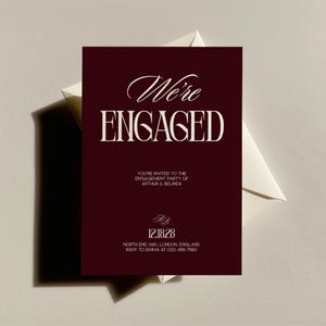 Puede incluir: Una invitación de compromiso burdeos con las palabras "We're ENGAGED" en escritura blanca y letras mayúsculas. La invitación incluye detalles para la fiesta de compromiso de Arthur y Belinda, con fecha 12.18.28 e información de RSVP.