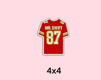 Puede incluir: Parche de hierro bordado en rojo y dorado de una camiseta de fútbol con el número 87 y el nombre "MR. SWIFT". El parche mide 4x4 pulgadas.