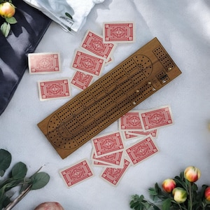 Tabuleiro de Cribbage de luxo personalizado em nogueira, com compartimento integrado para pinos, 9 pinos de metal e baralho de cartas. Ótimo presente para uma noite de jogos em família.