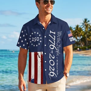 May include: A navy blue short-sleeve button-down shirt featuring a white star circle with the number 250, red and white vertical stripes, and the text We the People of the United States 1776-2026. A small American flag and US are on the sleeve.