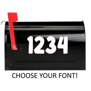 May include: A black mailbox with white numbers "1234" and a red signal flag. The text "CHOOSE YOUR FONT!" is below the mailbox. The mailbox is on a white background.