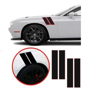 May include: White car with black racing stripes outlined in red. The image shows the front quarter of the car, with the stripes on the fender. Additional stripes are shown below the car. The car has black wheels.