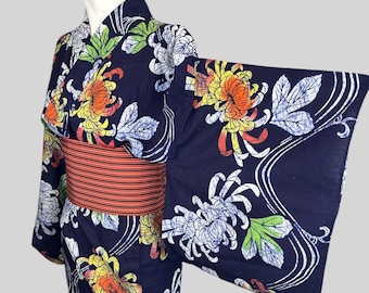 May include: A navy blue yukata with a floral pattern of white, yellow, orange, and red chrysanthemums. The yukata has a red and black striped sash.