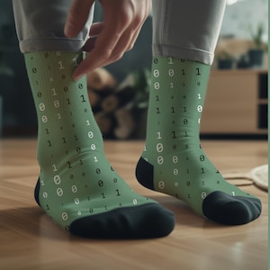 May include: A pair of green socks with a pattern of black and white zeros and ones. The socks are worn on a person's feet.