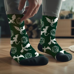 Könnte beinhalten: Ein Paar grüne Socken mit einem weißen Drachen- und Würfelmuster. Die Socken sind aus einem weichen, bequemen Material gefertigt und perfekt für den Alltag.