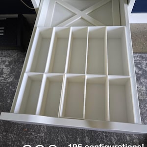 May include: White IKEA Alex drawer organizer with multiple compartments. The drawer is open, revealing the interior layout. The text "IKEA Alex Drawer Organizers" is at the top. The text "328" and "THE COLLECTIVE" are at the bottom, along with "196 configurations! Custom Options Available!"