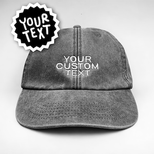 Könnte beinhalten: Eine anthrazitfarbene Baseballkappe mit verwaschenem Finish und weiß gesticktem Text YOUR CUSTOM TEXT auf der Vorderseite. Eine schwarze sternförmige Grafik mit dem weißen Text YOUR TEXT befindet sich in der oberen linken Ecke.