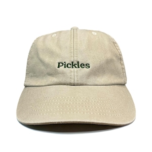 May include: A beige baseball cap featuring the word Pickles embroidered in dark green thread across the front centre. The cap has a six-panel construction with a curved brim, matching beige stitching, and a button at the top centre of the crown.