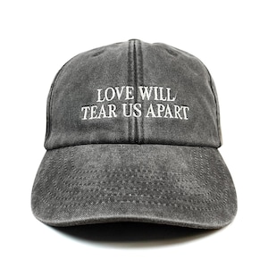 Geborduurde baseballpet met lage profiel en de tekst "Love Will Tear Us Apart"