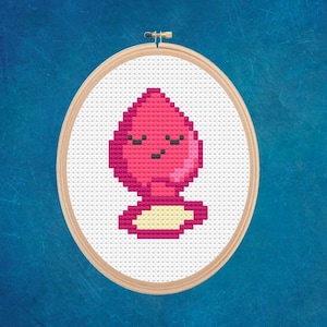 Puede incluir: Un diseño de punto de cruz rosa y amarillo de un globo de dibujos animados con una cara sonriente. El globo está en un aro.