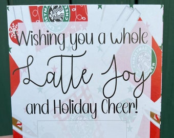 May include: A white card with a red and green Starbucks holiday design. The card says "Wishing you a whole Latte Joy and Holiday Cheer!" with a space to add a gift card. The card is signed "Love, Caroline Snavely".