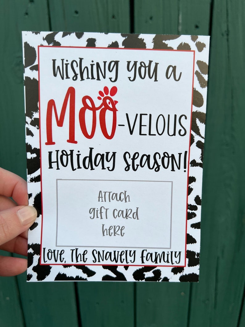 May include: A white card with black and white cow print design. The text "Wishing you a MOO-VELOUS Holiday season!" is in black with a red chicken graphic. The text "Attach gift card here" is in black. The text "Love, The Snavely family" is in black.