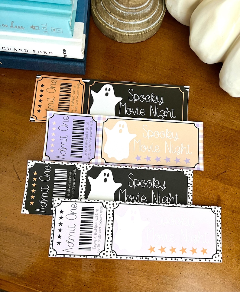K&ouml;nnte beinhalten: Vier druckbare Halloween-Kinotickets mit einem Geistermotiv und dem Text "Spooky Movie Night". Die Tickets sind schwarz, wei&szlig;, lila und orange mit schwarzen Punkten.