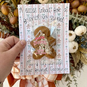 May include: A Christmas card with a gingerbread cookie in a clear wrapper. The card reads "A little treat for a friend so sweet" and "Merry Christmas! Your friend, Caroline."