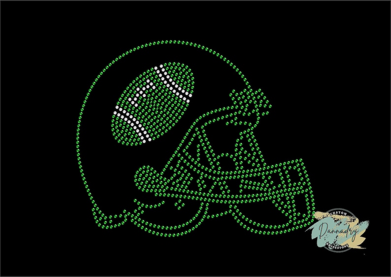 Puede incluir: Dise&ntilde;o de casco de f&uacute;tbol americano con diamantes de imitaci&oacute;n verdes y blancos. El casco est&aacute; bordeado con diamantes de imitaci&oacute;n verdes y tiene un bal&oacute;n de f&uacute;tbol en su interior.
