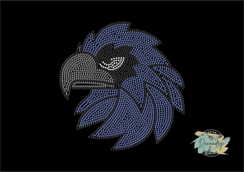 Puede incluir: Un dise&ntilde;o de cabeza de &aacute;guila azul y negro hecho con diamantes de imitaci&oacute;n. El &aacute;guila tiene una expresi&oacute;n feroz con un pico afilado y un ojo detallado.