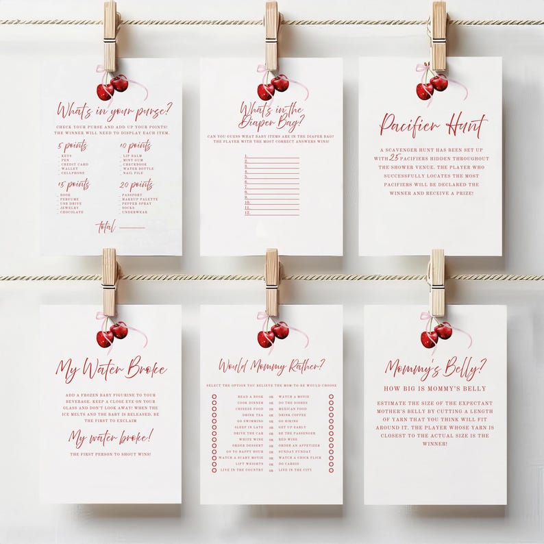 Op de afbeelding: Een set van tien printbare babyshower-spelkaarten met een kersenthema. De spellen omvatten "What's in your purse?", "What's in the diaper bag?", "Pacifier Hunt", "My Water Broke", "World Mommy Rather?" en "Mommy's Belly?"