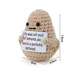 May include: A crocheted potato-shaped plush toy in beige, holding a sign that reads "Life was all out of lemons, so here's a potato instead." The toy measures 7.5 cm tall, 6 cm wide, and 4.5 cm deep.