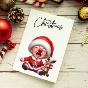 May include: A Christmas card featuring a cartoon baby dressed as Santa Claus, with a red nose and a reindeer toy. The card has the words "Merry Christmas" in elegant script.