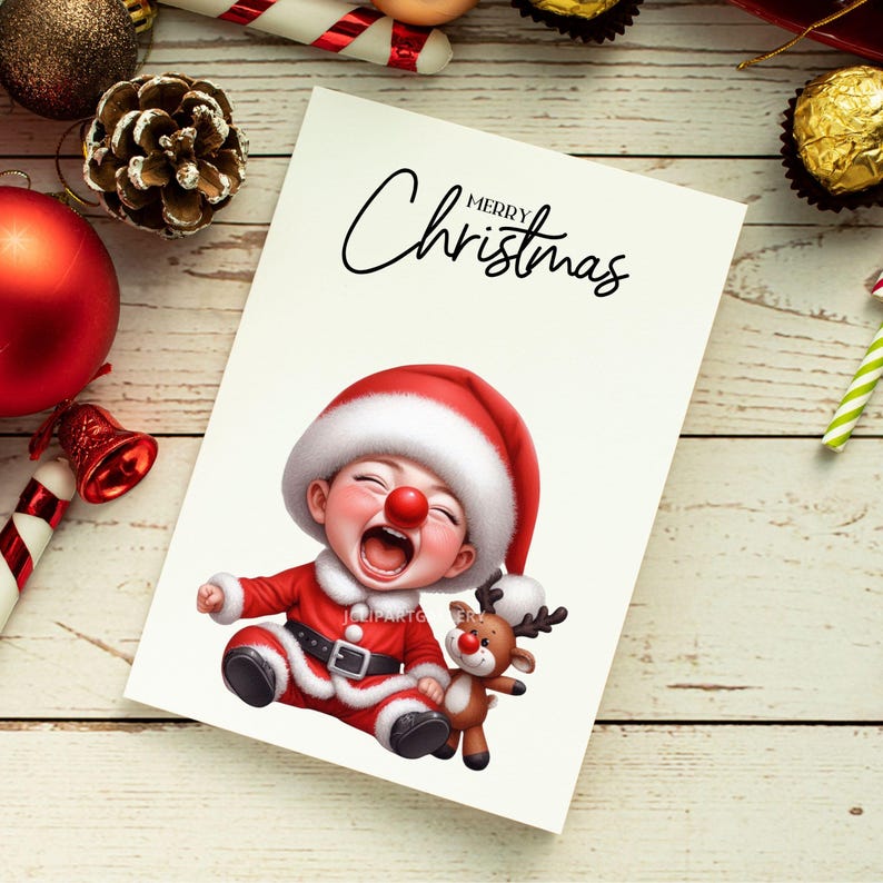 May include: A Christmas card featuring a cartoon baby dressed as Santa Claus, with a red nose and a reindeer toy. The card has the words "Merry Christmas" in elegant script.