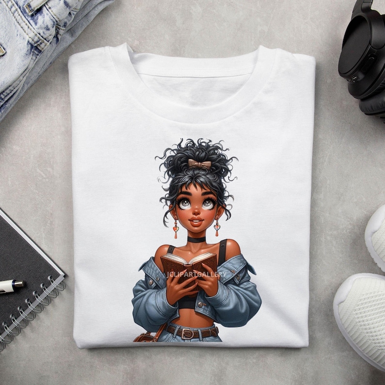 May include: White t-shirt with a graphic of a young woman with brown skin, curly black hair, and a blue denim jacket holding a book. The woman is looking up and smiling.