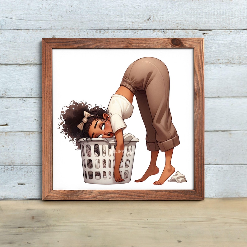 May include: A framed print featuring an illustration of a person leaning over a laundry basket. The person is wearing a white shirt and brown pants. The laundry basket is white and filled with clothes. The artwork is set against a light wood background.
