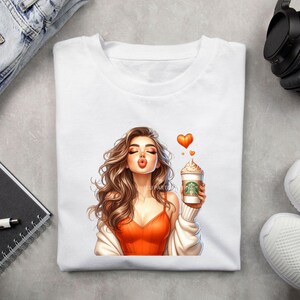 May include: A white t-shirt with a graphic of a woman blowing a kiss while holding a coffee cup with a heart-shaped design above her head.