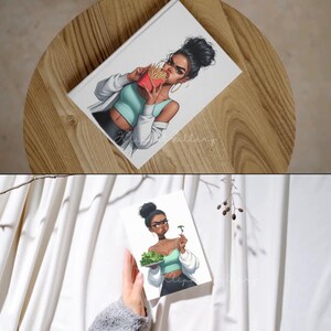 May include: A white notebook featuring an illustration of a woman eating french fries. The woman is wearing a teal top, white jacket, and black pants. The notebook is on a wooden surface. The text "Helip Gallery" is visible.