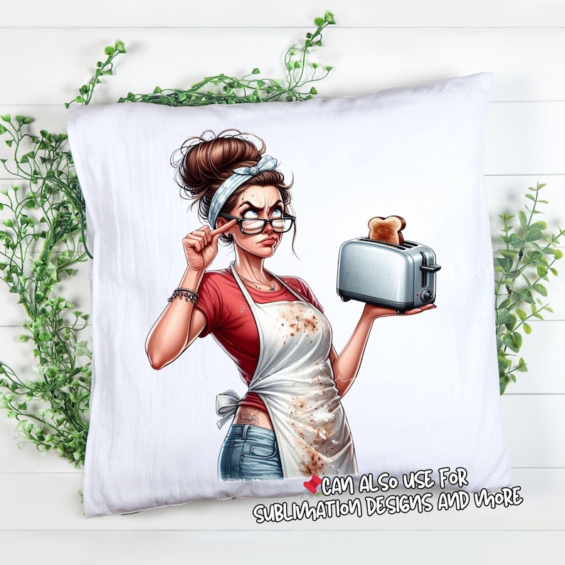 May include: White pillow with a cartoon illustration of a woman wearing glasses, a red shirt, and a white apron holding a toaster with toast. The woman has a stern expression. Text at the bottom reads "CAN ALSO USE FOR SUBLIMATION DESIGNS AND MORE."