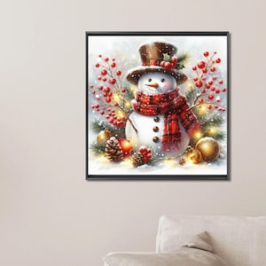 May include: A framed winter-themed artwork featuring a snowman wearing a brown top hat and a red plaid scarf. The snowman is surrounded by red berries, pine needles, and golden ornaments, with a snowy background.