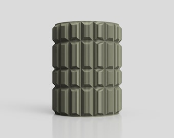 Puede incluir: Objeto cilíndrico en un tono verde oliva apagado, con un diseño geométrico. La superficie presenta un patrón repetitivo de líneas verticales y formas rectangulares, creando una apariencia texturizada. El diseño es simétrico.