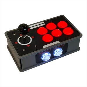 May include: A gray arcade game controller with a black joystick and six red buttons. The controller has two white buttons with the text "SELECT START" and is designed for video games.