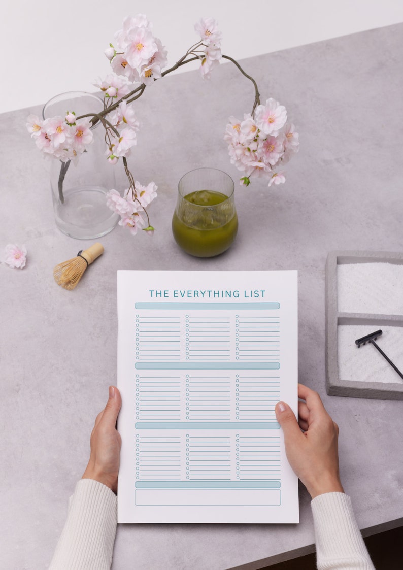 Puede incluir: Una hoja de papel blanca con el texto "THE EVERYTHING LIST" en la parte superior. El papel est&aacute; dividido en tres secciones con l&iacute;neas para escribir. Una persona est&aacute; sosteniendo el papel con sus manos.