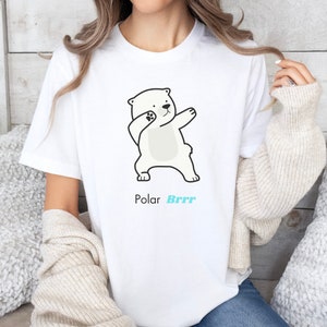 Pode incluir: Camiseta branca com um urso polar de desenho animado fazendo o dab. O texto "Polar Brrr" est&aacute; impresso abaixo do urso.