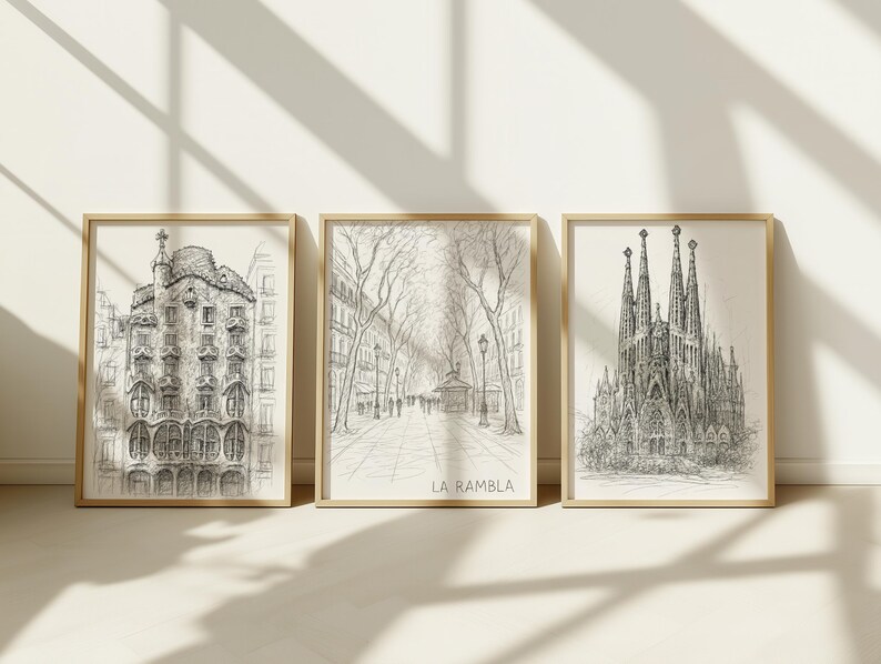 May include: Three framed black and white architectural sketches. The sketches depict a building with ornate details, a tree-lined street with the text "LA RAMBLA", and a cathedral with tall spires. The frames are a light wood color.