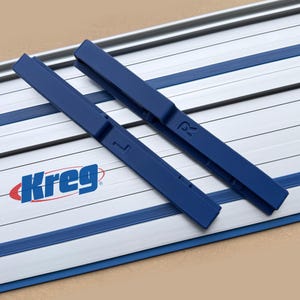 May include: Two blue Kreg track saw guide rails with the Kreg logo in red and blue. The rails are on a silver and blue track system. The rails have an "L" and "R" marking.