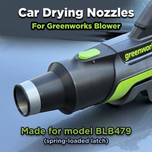 May include: Black and green car drying nozzle for Greenworks blower. The nozzle is designed for model BLB479 with a spring-loaded latch. The nozzle has a silver tip and a green button.