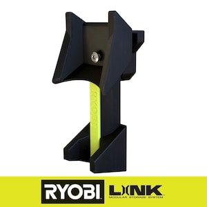 May include: A black modular storage system bracket with a neon green accent. The bracket has a unique shape with angled supports and a central post. The RYOBI and LINK logos are visible at the bottom.