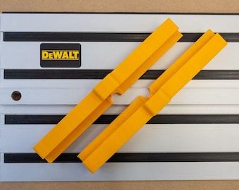 May include: Two yellow plastic track saw guides with DEWALT logo on a gray and black track system.