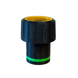 May include: A black plastic object with a yellow interior rim and a green stripe. The object has a ridged, cylindrical top and a narrower, cylindrical base. Arrows are visible on the base.