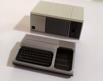 May include: A vintage-style computer with a beige tower and a separate keyboard. The tower has a floppy disk drive and a series of vents on the side. The keyboard has a gray and black color scheme.