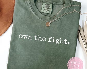 Camiseta Comfort Colors Own the Fight: Camiseta de conscientização sobre o câncer de mama